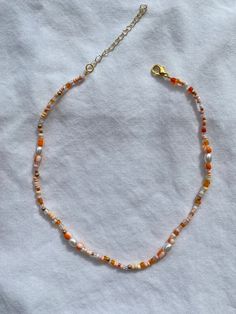 Orange Beaded Choker Necklace - Made with a selection of beads, Fireline jewellery thread and gold plated findings. - Comes in Small (13-15 inches), Medium (15-17 inches) and Large (17-19 inches). (Sizes include an extra 2 inches of extender chain to adjust to the perfect size). Cheap Vintage Orange Beaded Necklaces, Autumn Seed Bead Necklace, Orange Beaded Jewelry, Orange Choker With Colorful Beads, Orange Beaded Necklaces With Spacer Beads As Gift, Handmade Orange Heishi Beads Jewelry, Orange Beaded Choker With Tiny Beads, Orange Tiny Beads Choker Necklace, Orange Necklaces With Gold Beads For Gifts