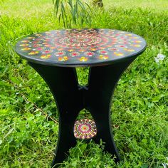 a black table sitting on top of a lush green field