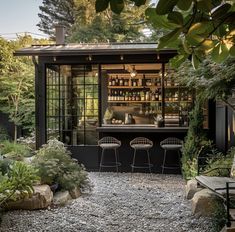 an outdoor bar in the middle of a gravel area with chairs and tables around it