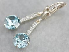 These lovely zircons are bright and bold! The color is cool, luscious sky blue, with plenty of sparkles! The long bar at the center is inlaid with sparkling diamonds, at the very top are the earring wires, hinged lever backs which are brand new, 14K white gold with a simple polished design. These are comfortable to wear and very secure! Metal: 14K White Gold Gem: 2 Blue Zircon totaling 6.81 Carats Gem Measurements: 8.2 mm, Round Accents: 10 Diamonds totaling .10 Carats, F in Color, VS in Clarity Blue Diamond Earrings, White Gold Drop Earrings, Aquamarine Pendant, Cameo Ring, Blue Zircon, Diamond Drops, Gold Drop Earrings, Drop Pendant, Sparkle Diamonds