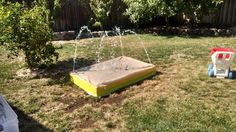 an inflatable mattress is sitting on the ground near some water spouting from it