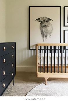 a baby's room with pictures on the wall and a crib next to it