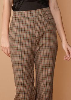 Expertly crafted with a side zipper closure and button detail, the Women's Wide Cuff Trouser in Peach Gingham, fulfilled by our friends at Shop at Konus, is both comfortable and elegant. With convenient pockets and a fully lined design, these trousers are the perfect addition to any occasion. Made with a blend of 65% Tencel, 32% Rayon, and 3% Spandex, and lined with 100% Polyester, these trousers are a must-have for any fashion-forward woman. Available in small model size. Fall Gingham Trousers, Gingham Trousers For Fall, Plaid Trousers, Cropped Flares, Wide Cuff, Plaid Pants, Button Detail, Preppy Style, Plaid Pattern