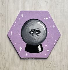 a painting of an eyeball with stars on the side and purple hexagonal background