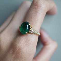 Read about our payment plans before proceeding.This is what dreams are made of. This emerald ring features an insanely gorgeous deep green natural cabochon emerald stone, embellished with 57 natural white diamonds with details like phoenix wings. A classy and sleek ring to treasure forever. Handcrafted in your choice of 14K yellow gold, rose gold, and white gold. The emerald shown is the exact same emerald you will receive. 14K solid gold Natural 12*9mm natural cabochon emerald. Approx. 2.8ct~. Luxury Oval Emerald Birthstone Ring, Yellow Gold Emerald Ring With Oval Cabochon, Yellow Gold Emerald Ring Oval Cabochon, Fine Jewelry Emerald Ring With Oval Cabochon, Fine Jewelry Emerald Oval Cabochon Ring, Emerald Oval Cabochon Ring As A Gift, Exquisite Oval Green Emerald Ring, Elegant Emerald Ring With Oval Cabochon, Exquisite Green Oval Emerald Ring