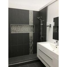 a black and white bathroom with a shower head, sink and mirror on the wall