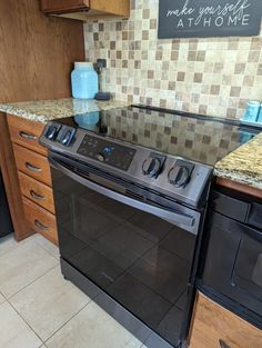 a black stove top oven sitting in a kitchen next to wooden cabinets and counter tops