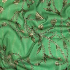 a green fabric with flowers and leaves on it