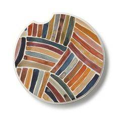 a decorative plate with multicolored stripes on the edge and bottom, sitting on a white surface