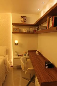 a room with a bed, desk and bookshelf on the shelves above it