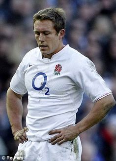 a rugby player is looking down at the ground while holding his hands on his hips