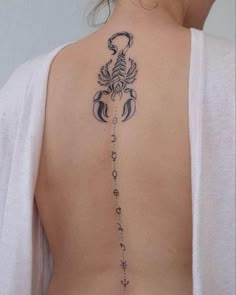 the back of a woman's neck with an intricate tattoo on her left side