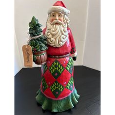 a santa clause figurine holding a potted plant