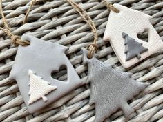 three ceramic ornaments hanging from twine on wicker tablecloth with woven string attached to each ornament