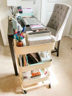 a laptop computer sitting on top of a desk next to a shelf filled with office supplies