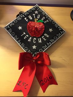 a graduation cap with a red apple on it and the words future teacher written on it