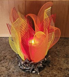 an orange and yellow candle sitting on top of a counter