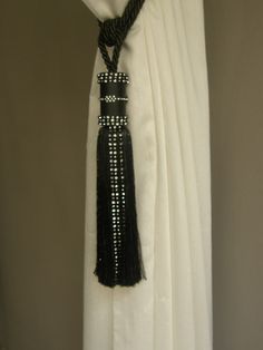 a black and white tassel hanging from the side of a curtain