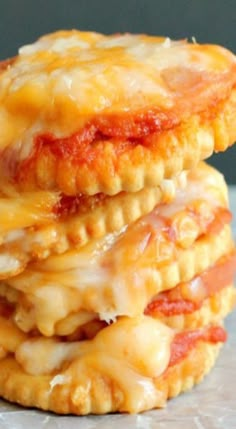 three cheesy pastries stacked on top of each other with cheese and tomato sauce