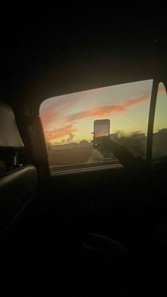 the sun is setting in the distance as seen from inside a car