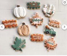 cookies decorated with thanksgiving sayings are arranged on a white surface and placed in the shape of pumpkins