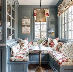 a room that has some couches and a table in the corner with flowers on it