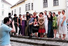 a group of people standing on steps in front of a building with cameras around them