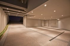 an empty parking garage with lights on the ceiling and doors open to let in light