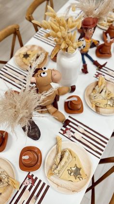 a table topped with plates and vases filled with food