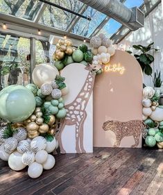 a display with balloons and decorations in the shape of giraffe's head