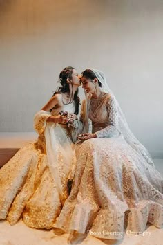 two women in wedding dresses sitting next to each other