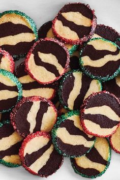 a pile of decorated cookies sitting on top of a white table covered in green and red frosting