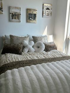 a bed with white pillows and leopard print on it