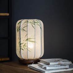 a lamp that is sitting on top of a table next to some books and a chair