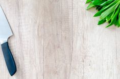 a knife and some green leaves on a table