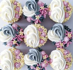 cupcakes with white and blue frosting are arranged in the shape of flowers