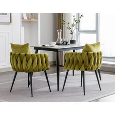 two green chairs sitting in front of a table