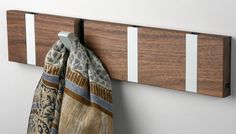 a towel rack with two towels hanging from it's sides and three hooks on the wall