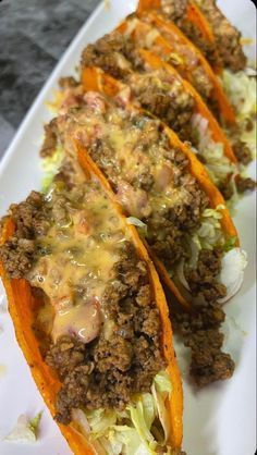 three stuffed sweet potatoes with meat and cheese on them are sitting on a white plate