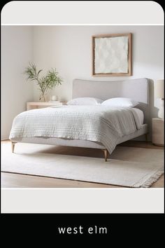 a bed with white sheets and pillows in a room next to a rug on the floor