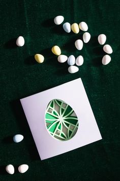 some white and green candies are scattered around a card that has an ornament on it