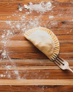 a piece of pie sitting on top of a wooden table covered in powdered sugar