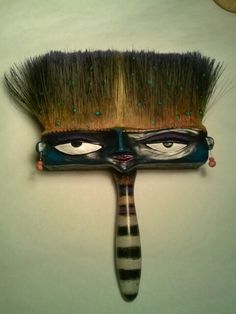 a close up of a brush with eyes painted on it's face and hair