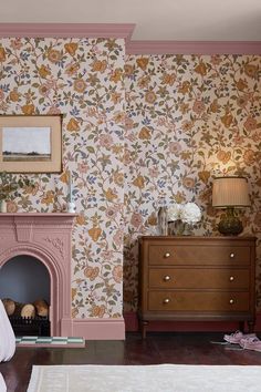 a bedroom with floral wallpaper and a fireplace