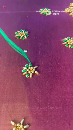 some green and gold jewelry on a purple surface