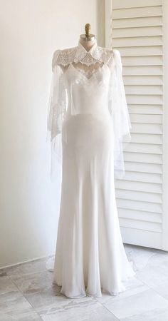 a white wedding dress on display in front of a window