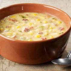 a brown bowl filled with soup next to a spoon