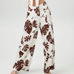 A Pair Of Satin Pants Featuring An Allover Tropical Leaf Print, Mid Rise, Zip Fly With Button Closure, Back Welt Pockets, And A Wide Leg. Content + Care - 100% Polyester - Hand Wash Cold Size + Fit - Model Is 5'8" And Wearing A Small - Measured From A Size Xs - Inseam: 31" Trendy White Wide Leg Pants For Vacation, Forever 21 White Spring Bottoms, Trendy White Wide Leg Pants For Day Out, Forever 21 Bottoms For Spring Vacation, Forever 21 High-waisted Pants, Forever 21 High Waist Vacation Bottoms, Forever 21 High-waisted Summer Pants, Forever 21 High-waist Bottoms For Vacation, Forever 21 High Waist Bottoms For Vacation