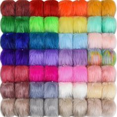 many colors of dyed yarn are arranged in rows on a white background and one is multicolored