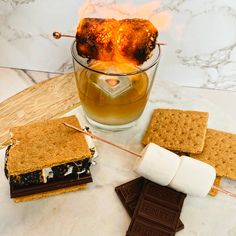 a glass filled with ice cream and marshmallows on top of a table